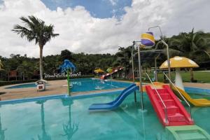 a pool at a resort with a water park at OYO 1167 Ban Pa Rim Khuean in Ban Tha Dan
