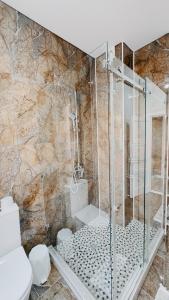 ein Badezimmer mit Dusche mit Glasduschkabine in der Unterkunft Жк Керуен Сарай in Türkistan