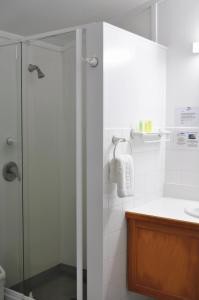 a bathroom with a shower with a glass door at South Pacific Resort Hotel in Burnt Pine