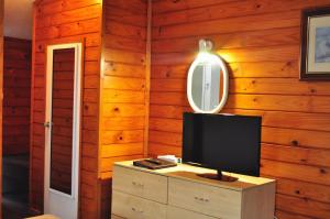 a television on a dresser in a room with wooden walls at South Pacific Resort Hotel in Burnt Pine