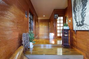 un couloir aux murs lambrissés et un couloir avec des bancs dans l'établissement 和がと Wagato Kawaguchiko, à Fujikawaguchiko