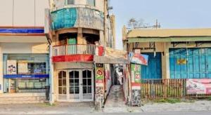 ein altes Gebäude am Straßenrand in der Unterkunft Hotel O Penginapan Hj Lilis 2 Syariah in Sukabumi