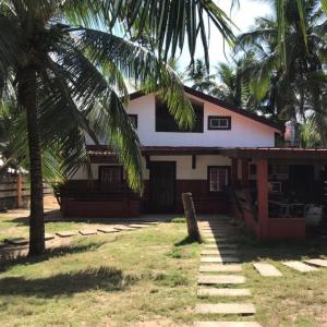 una casa con una palma di fronte di EU Beach Resort 