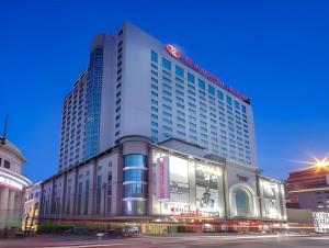 ein großes Gebäude in einer Stadt mit Straße in der Unterkunft Ramada Plaza Shenyang Citycenter in Shenyang