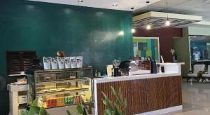 ein Restaurant mit einer grünen Wand und einer Theke in der Unterkunft Holiday Spa Hotel in Mabolo