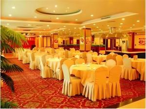 une salle de banquet avec des tables et des chaises blanches dans l'établissement GreenTree Alliance Guangdong Shenzhen Pinghu Avenue Jingdu Town Hotel, à Tiantangwei