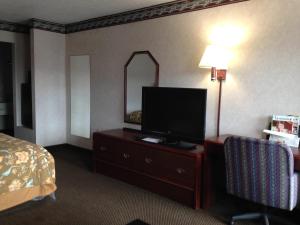 une chambre d'hôtel avec une télévision sur une commode et un lit dans l'établissement America's Best Value Inn Clarksdale, à Clarksdale