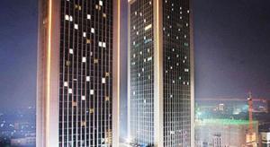 Un grand bâtiment avec des lumières allumées la nuit dans l'établissement Shanxi World Trade Hotel, à Taiyuan