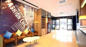 ein Wohnzimmer mit Sofas und Stühlen in einem Gebäude in der Unterkunft IU Hotel Tianjin Tianta Scenic Spot Wujiayao Metro Station in Tianjin