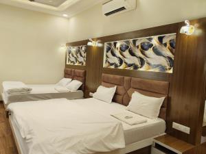 two beds in a room with a painting on the wall at Pink Mahal Hotel & Resort in Jaipur +58 photos