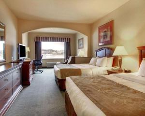 ein Hotelzimmer mit zwei Betten und einem Fernseher in der Unterkunft Clarion Suites Vidalia Riverfront in Vidalia