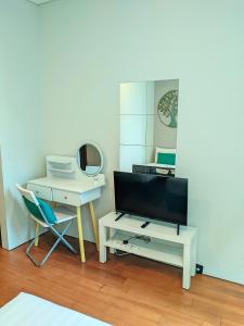 a living room with a tv and a table and a chair at Sky Suite KLCC Apartment klcc in Gua Sai