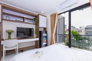 un salon avec une grande fenêtre et une télévision dans l'établissement Hera West Lake Apartment, à Hanoï