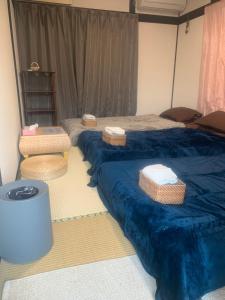 due letti in una stanza con lenzuola blu e cestini di 仁信小屋 a Tokyo