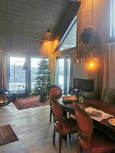 Un comedor con mesa y sillas y una habitación con un árbol. en Bjerghytte Med Panoramaudsigt I Oppdal, en Gorset 32 fotos más
