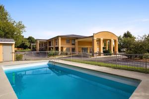 a swimming pool in front of a house at Days Inn by Wyndham Blythewood North Columbia in Blythewood