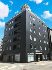 un grand bâtiment noir au coin d'une rue dans l'établissement Niigata Keihin Hotel, à Nuttari