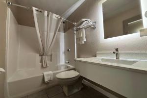 a white bathroom with a toilet and a sink at Super 8 by Wyndham Alton in Alton +17 photos