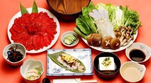 ein Tisch mit mehreren Tellern mit Essen darauf in der Unterkunft Hotel Heights in Yamanouchi