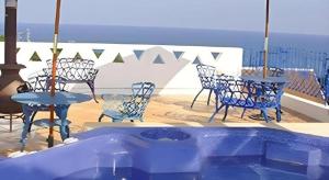 d'une terrasse avec un bain à remous, des tables et des chaises. dans l'établissement Arabian Art Hotel & Gallery, à Kawaguchi