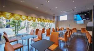a restaurant with tables and chairs and a large window at Hotel Sealuck Pal Yaizu in Hanazawa