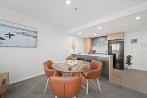 eine Küche und ein Esszimmer mit Tisch und Stühlen in der Unterkunft Sleek 2-Bed Apartment with Rooftop Garden Access in Belconnen