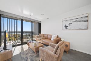 ein Wohnzimmer mit Sofa und Tisch in der Unterkunft Sleek 2-Bed Apartment with Rooftop Garden Access in Belconnen