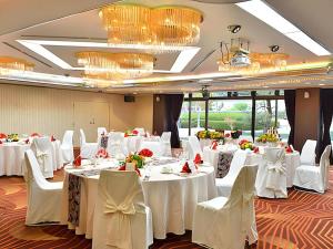 une salle de banquet avec des tables blanches, des chaises et des lustres dans l'établissement Hotel Ligare Kasugano, à Nara