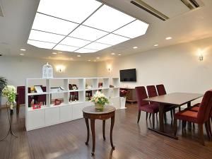 une salle à manger avec une table et des chaises et une télévision dans l'établissement Hotel Ligare Kasugano, à Nara
