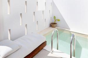 una casa con piscina de cristal con una cama y una planta en ALERÓ Seaside Skyros Resort, en Skiros