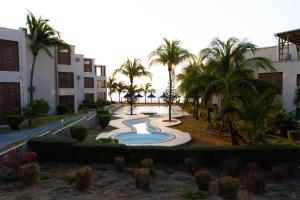 a resort yard with a swimming pool and palm trees at Cozy Oceanview Apartment D5 in Flic-en-Flac