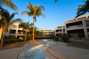 a walkway with palm trees in front of a building at Cozy Oceanview Apartment D5 in Flic-en-Flac