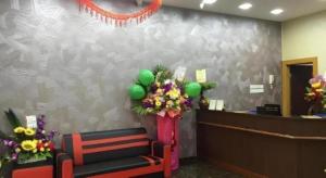 un hall d'accueil avec une salle d'attente avec des fleurs et des ballons dans l'établissement ID Hotel Yayasan, à Buluh Kasap