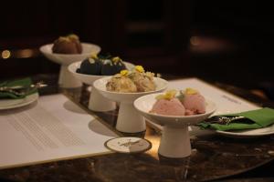 una mesa con cuatro cuencos de postres en una bandeja en Maxwell Reserve Singapore, Autograph Collection, en Singapur