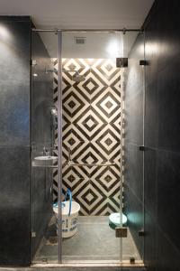 a bathroom with a glass shower with a toilet at Blue Sapphire Studio Apartment in Ghaziabad