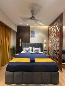 a bedroom with a large bed with a blue and yellow blanket at Blue Sapphire Studio Apartment in Ghaziabad