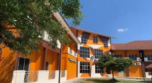 an orange building with a tree in front of it at PAHANG REST HOUSE @ BERA in Kampong Kerayong