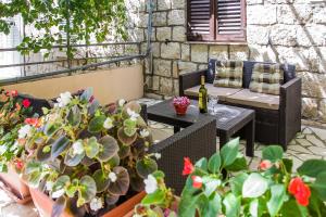 a patio with a table and chairs and potted plants at Ante Apartments in Trstenik