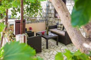 a patio with a table and a bench and a table at Ante Apartments in Trstenik