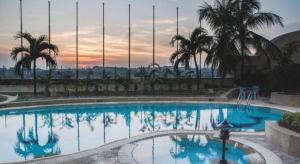 a large swimming pool with palm trees in the background at Summit Hotel Subang USJ in Subang Jaya