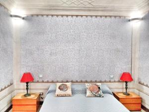 a bedroom with a bed with two red lamps at Ampio appartamento di Charme con 2 camere, 2 bagni, terrazza, aria condizionata, in posizione Centralissima in Cecina