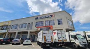 Zwei Lieferwagen parkten vor einem Gebäude in der Unterkunft Sg. Paka Hotel in Kampong Kongsi