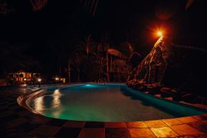 ein Schwimmbad in der Nacht mit Straßenbeleuchtung in der Unterkunft Naibor Villa in Themi + 5 Fotos