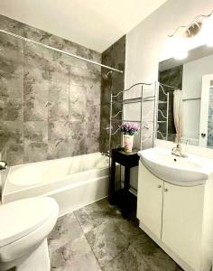 a bathroom with a sink and a tub and a toilet at Quiet King Bedroom near DT Toronto in Toronto