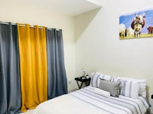 a bedroom with yellow and blue curtains and a bed at JB Guest Rooms in Walvis Bay
