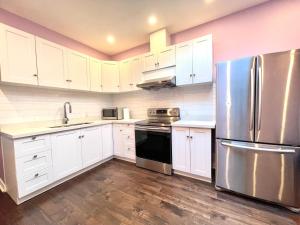a kitchen with white cabinets and a stainless steel refrigerator at Quiet King Bedroom near DT Toronto in Toronto