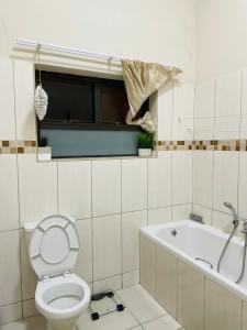 a bathroom with a toilet and a bath tub at JB Guest Rooms in Walvis Bay