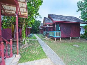eine Reihe von Häusern mit einer Bank im Hof in der Unterkunft OYO 90620 Mahseer Chalet in Kuala Tahan