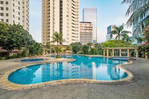 a large swimming pool in a city with tall buildings at Aryaduta Suite Semanggi in Jakarta
