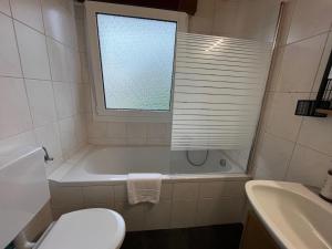 ein Badezimmer mit Badewanne und Toilette und einem Fenster in der Unterkunft Terrassenwohnung in ruhiger Lage -3 Zimmer A96 nähe in Schönwag + 15 Fotos